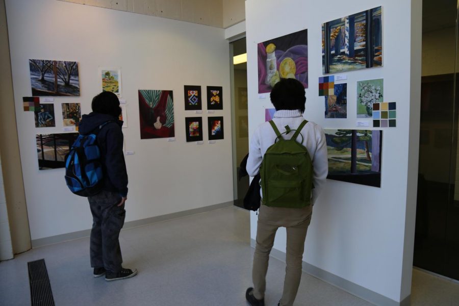 Students viewing art displayed on the walls of The Niche Gallery at Century College West Campus.