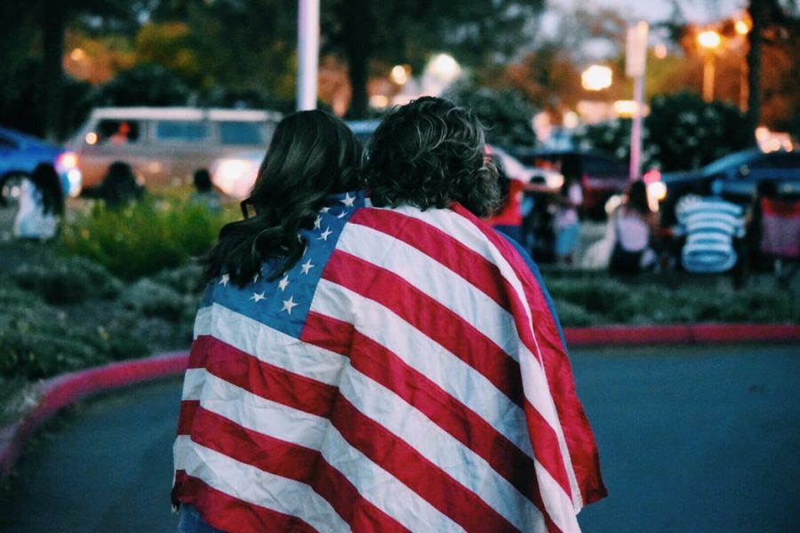Two people draped in an American flag.