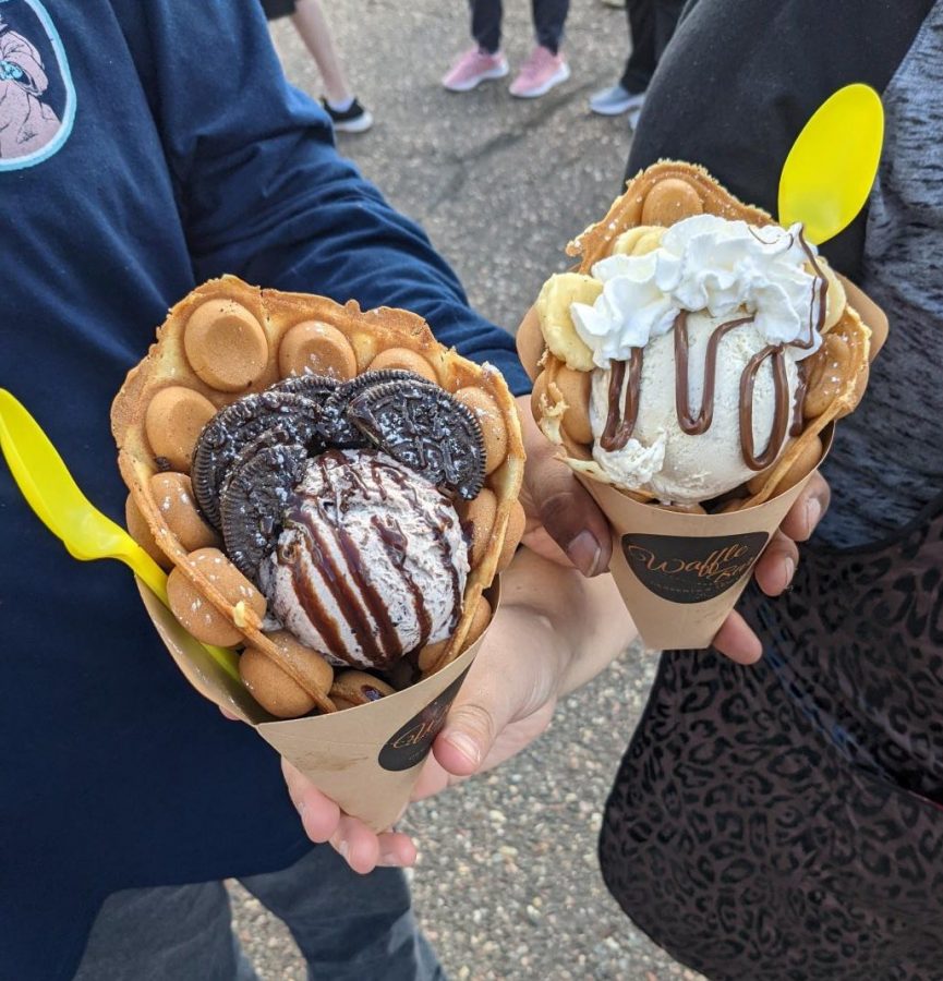 Two Waffle Bar, waffle cone sundaes held by students in line.