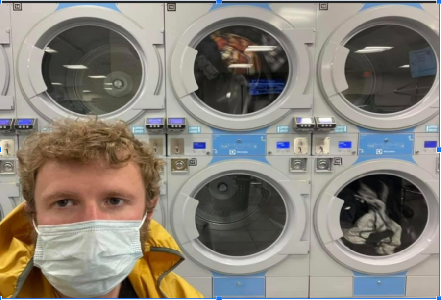 Author Erick standing in front of the dryers at the laundry mat pondering whether or not his pairs of socks with all match up.