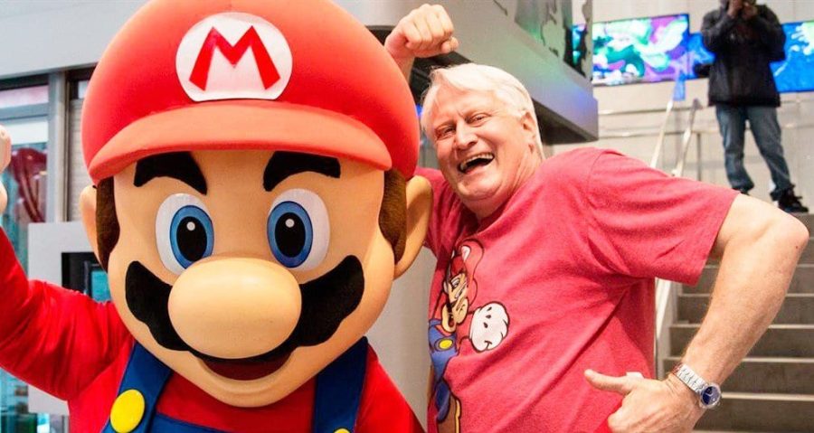 Charles Martinet, the voice of Mario in the animated upcoming movie, standing with Mario Mascot at a promotional event.