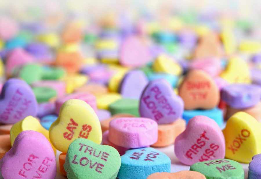 A giant pile of conversation hearts. The camera focuses in on two hearts, one saying, Puppy Love and the other True Love.