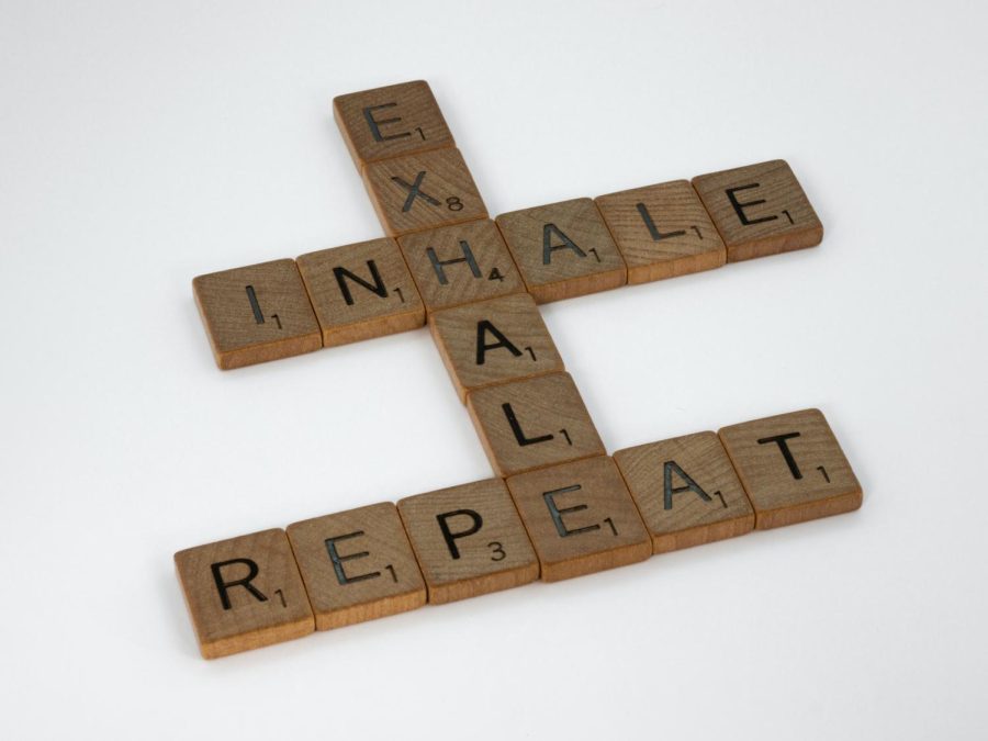 Exhale, Inhale, and Repeat are spelled out in Scrabble letters on a white backdrop.