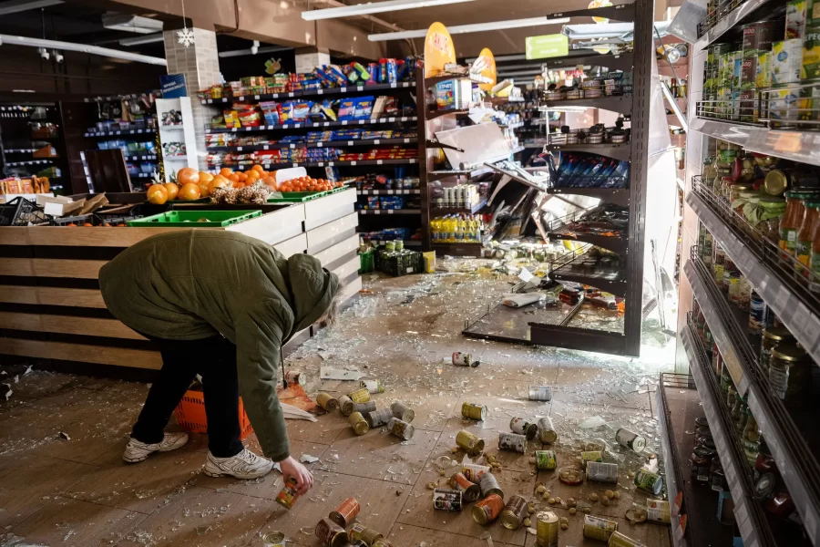 Civilian picking up a grocery store after bombing.