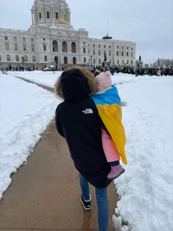 Luida holds her daughter as they walk home from the protest at the capital.