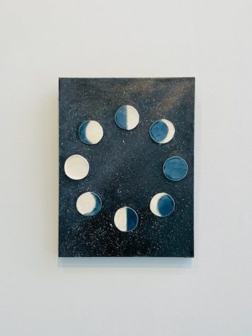 Ash Davis presents a mixed media work on canvas with ceramic elements representing phases of the moon. 